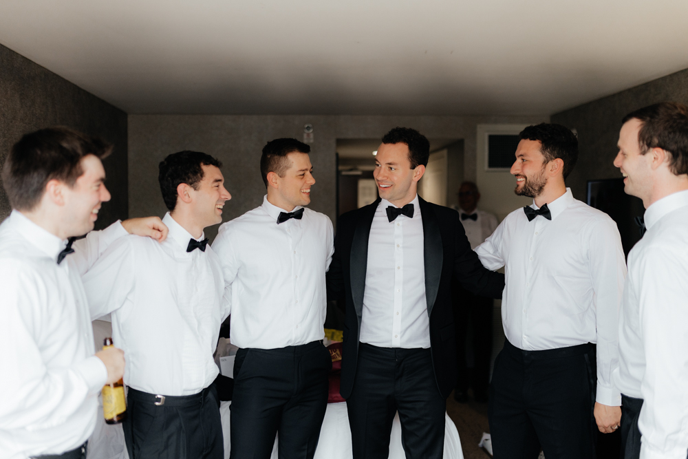 Groom hanging out with groomsmen on his wedding day