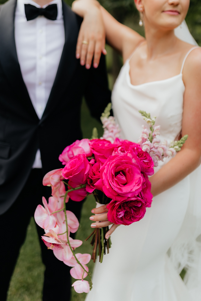 Elegant bride and groom on their wedding day with hot pink bouquet