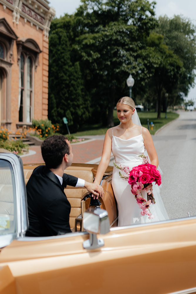 Classy bride and groom on their wedding day with a tan vintage car