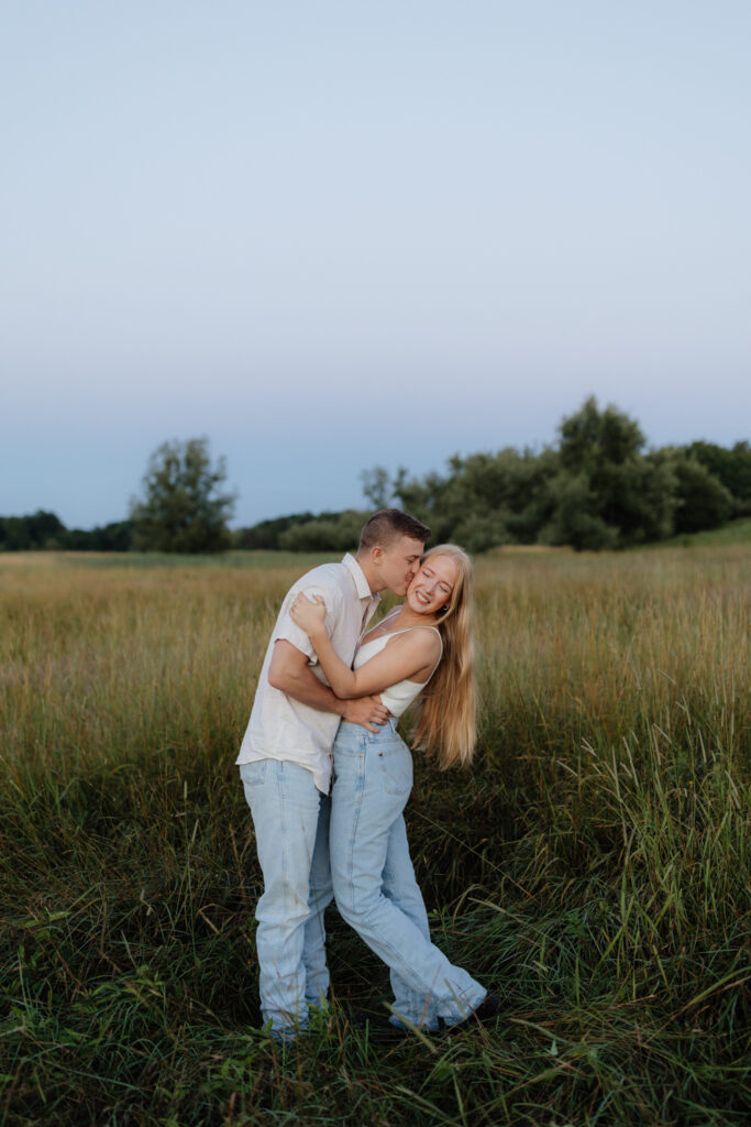 Couple in a field at sunrise kissing