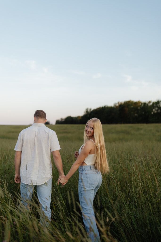 Couple in a field at sunrise walking