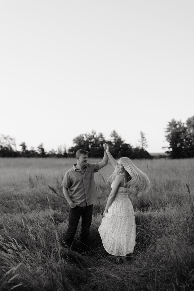 Couple in a field at sunrise dancing