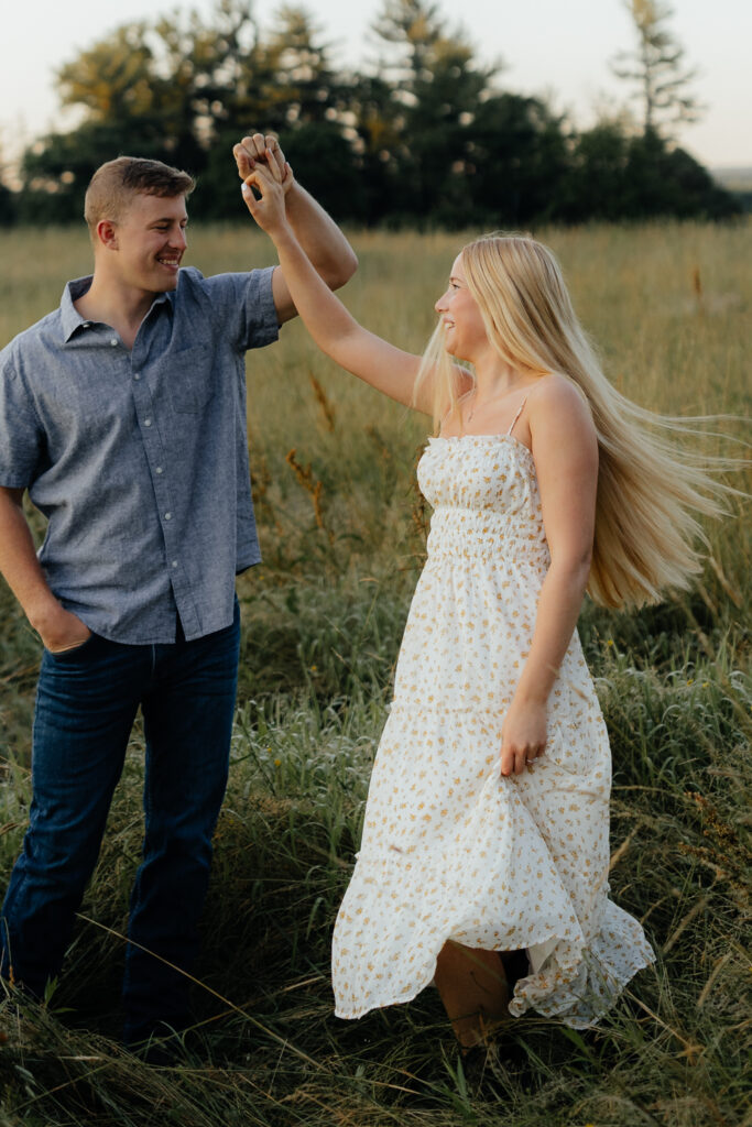 Couple in a field at sunrise dancing