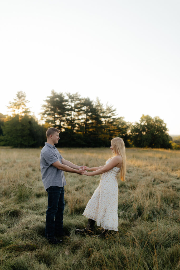 Couple in a field at sunrise dancing