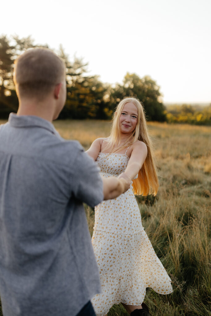 Couple in a field at sunrise dancing