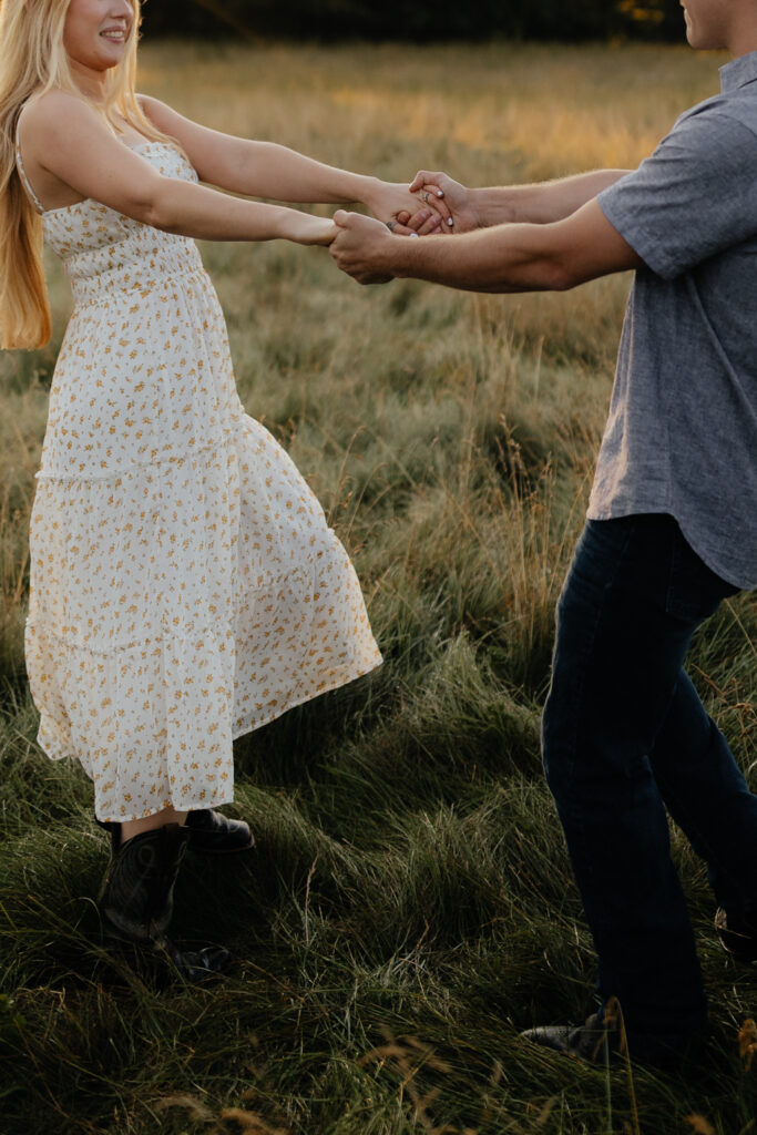 Couple in a field at sunrise dancing