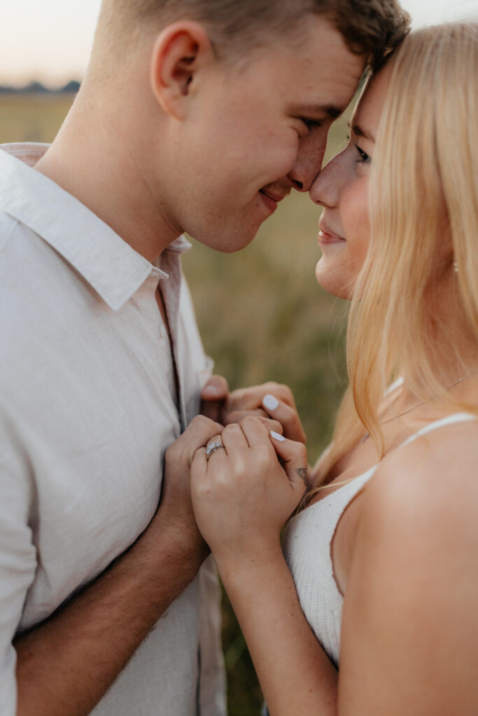 Couple in a field at sunrise holding hands