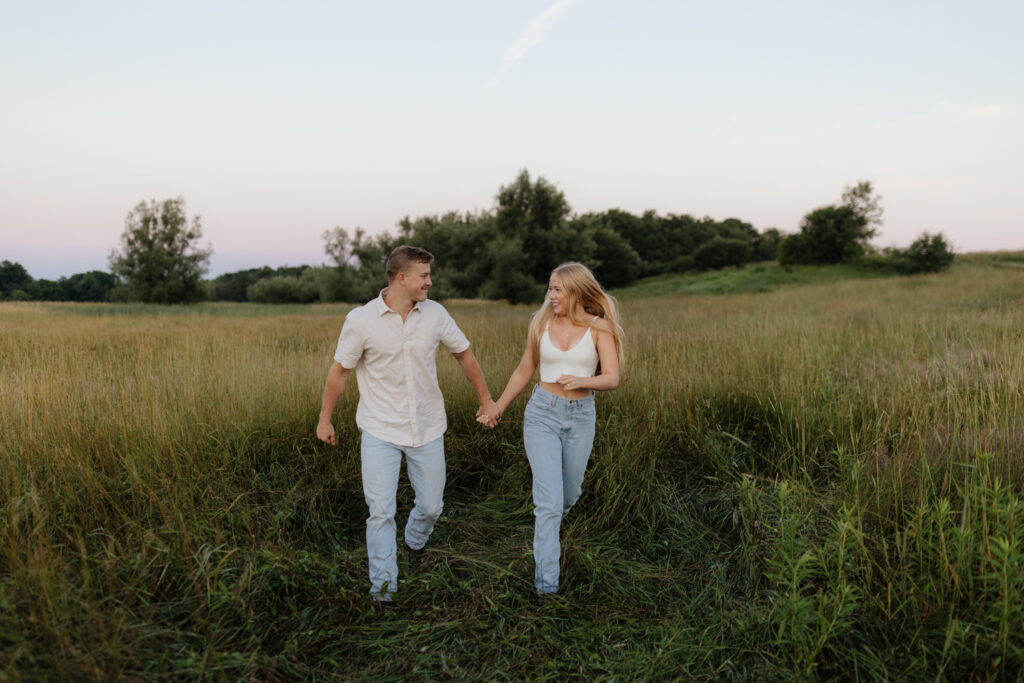 Couple in a field at sunrise running