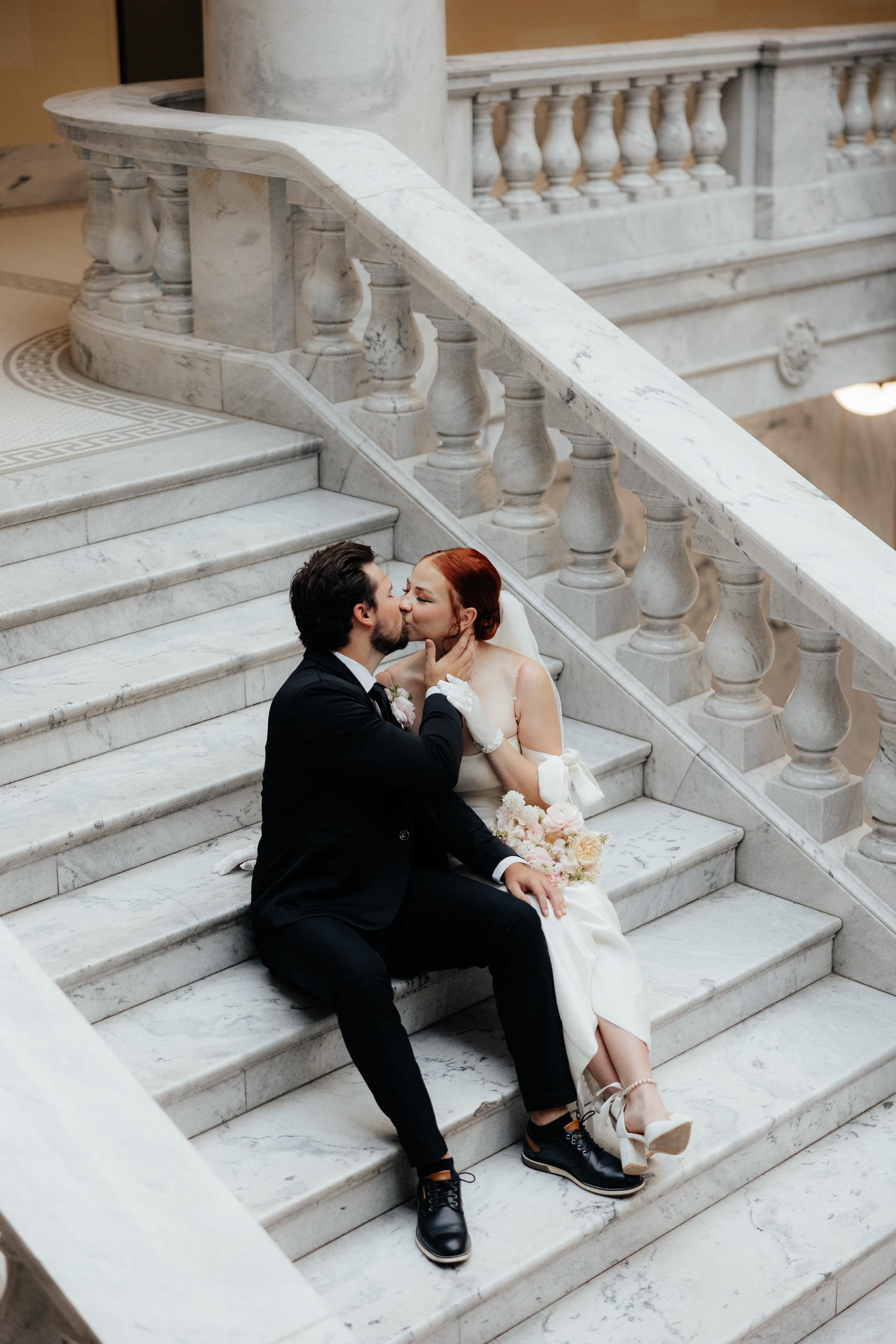 Couple eloping in salt lake city sitting on steps