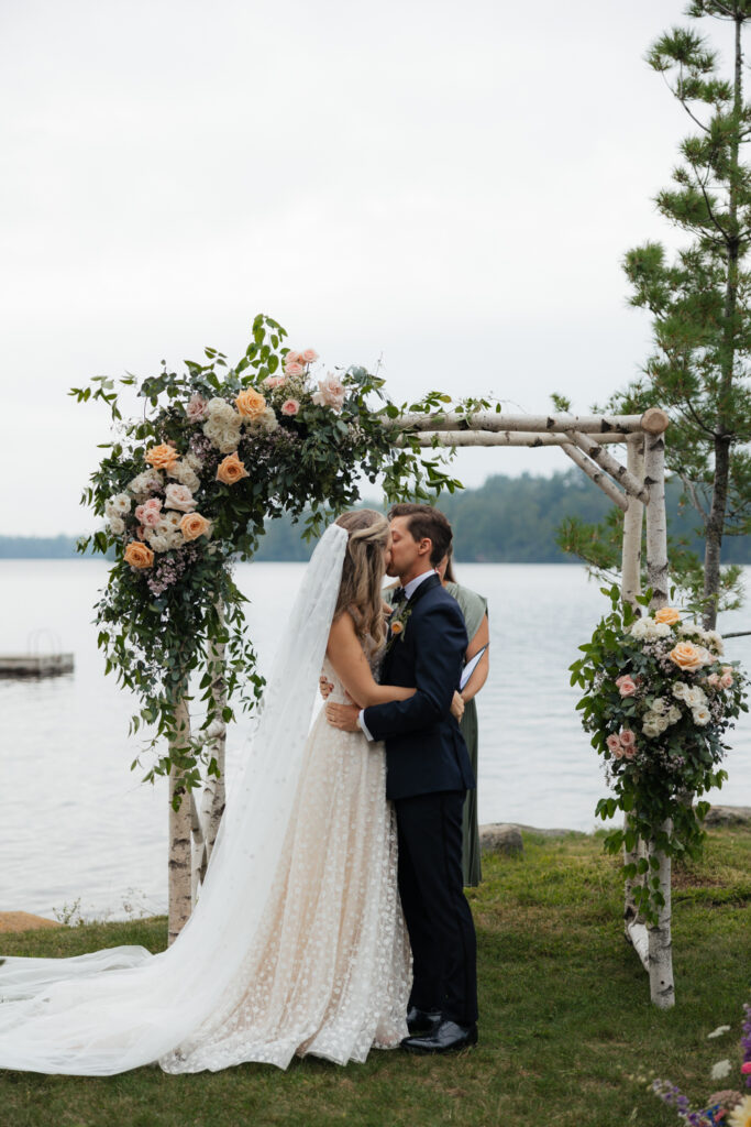 first kiss at lakeside ceremony in the Adirondacks