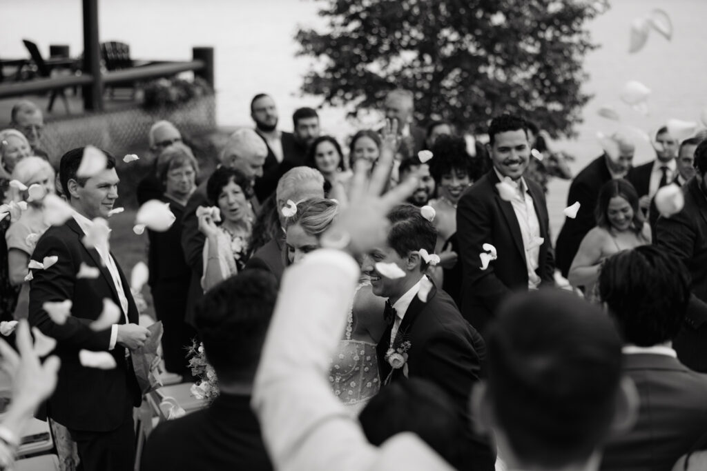 guests throw petals lakeside ceremony in the Adirondacks