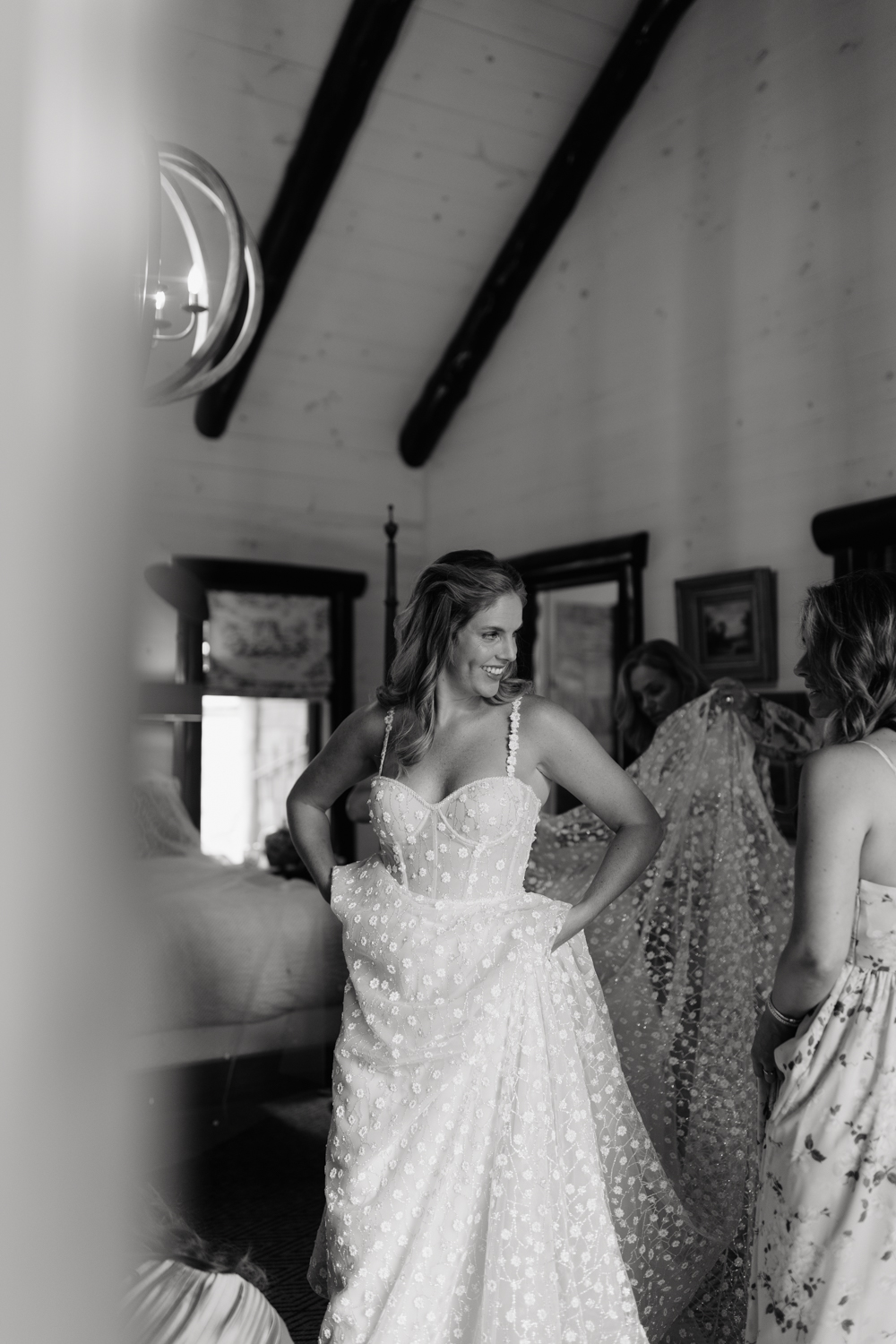 bridesmaids helping bride in her dress on her wedding day