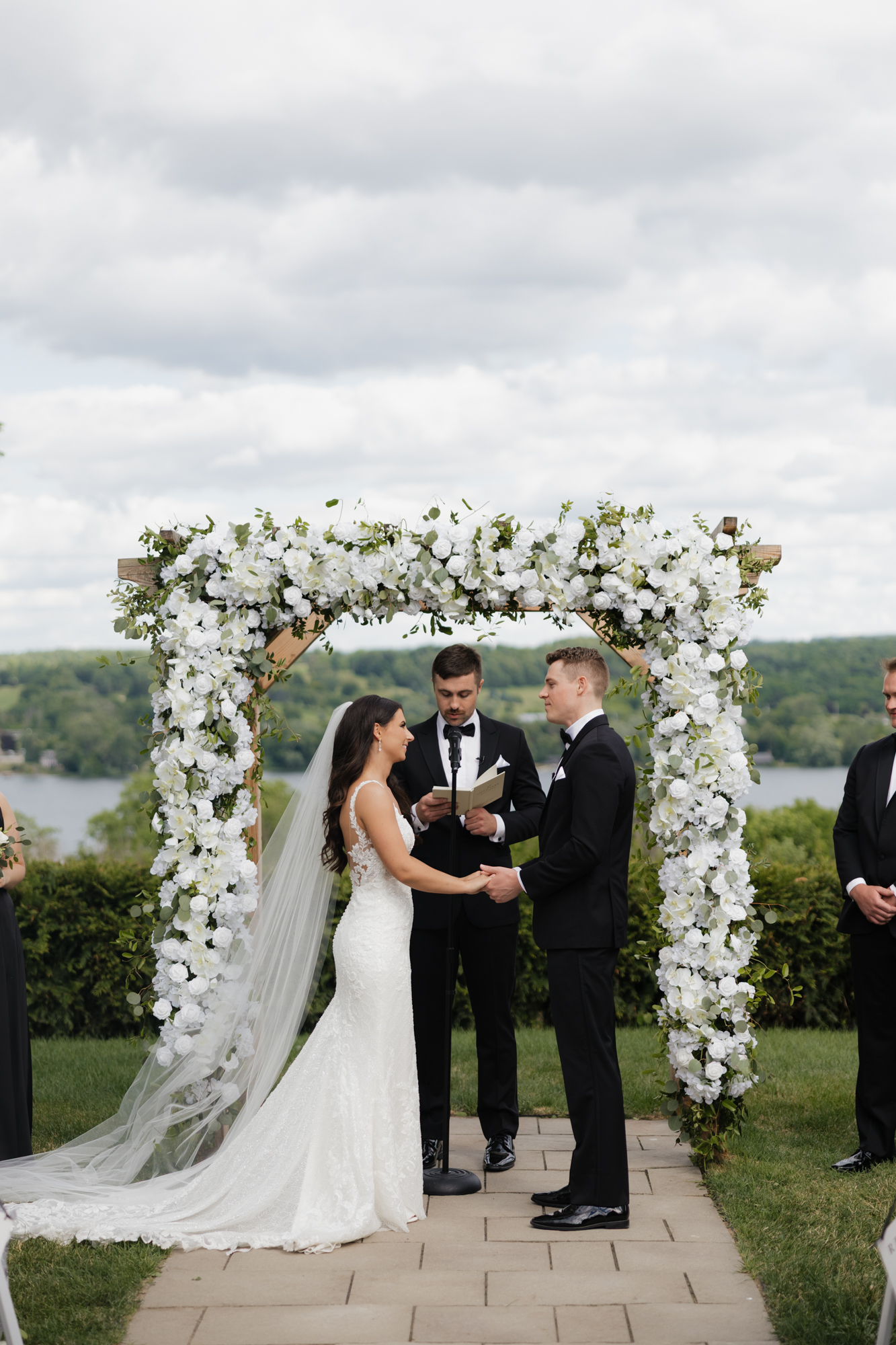 Bride and groom stand at the arbor at Crispin Hill in Penn Yan NY