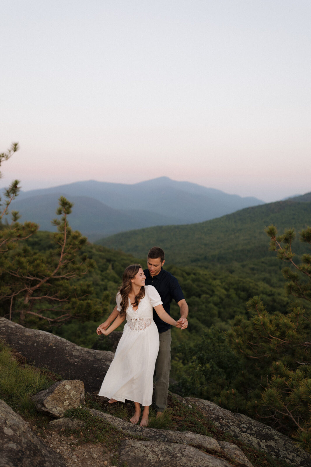 Engaged couple dance on top of a mountain in the ADK