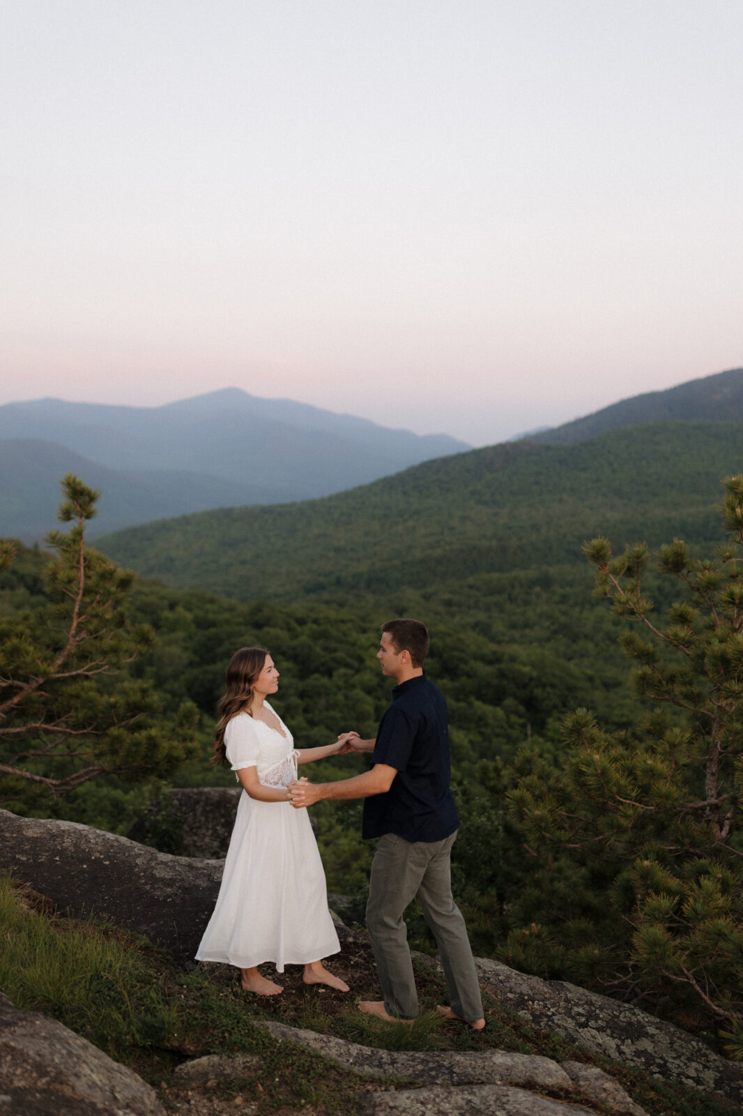Engaged couple dance on top of a mountain in the ADK