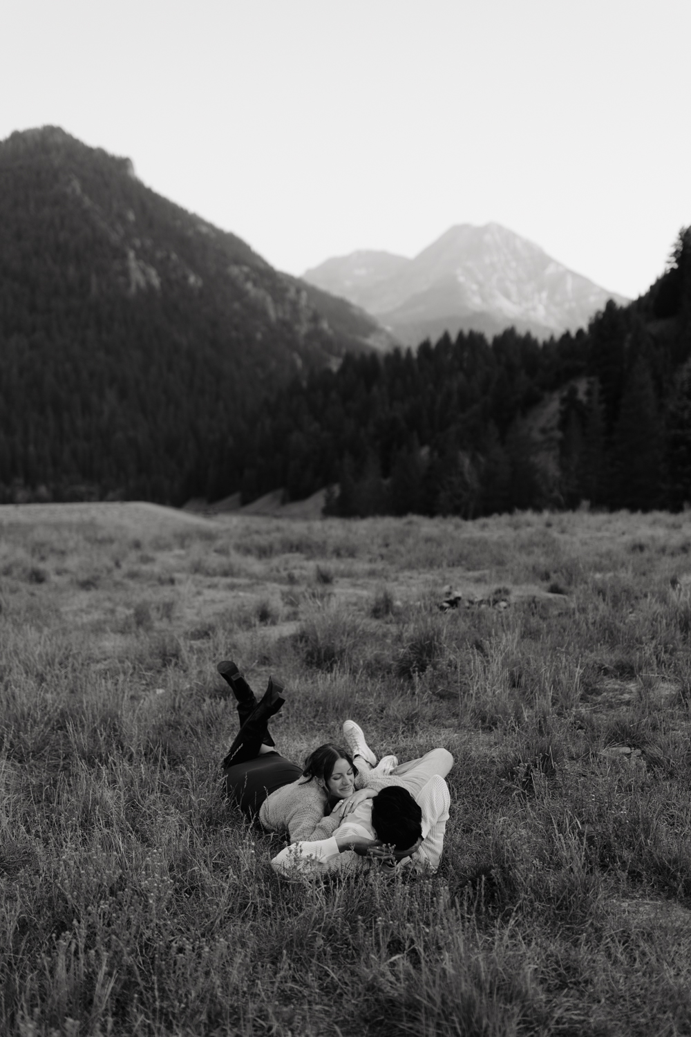 Couple plays in the grass at TIbble Fork Reservoir in Utah