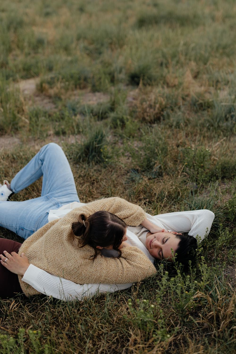Couple plays in the grass at TIbble Fork Reservoir in Utah