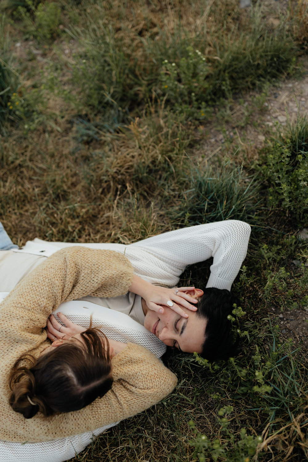 Couple plays in the grass at TIbble Fork Reservoir in Utah