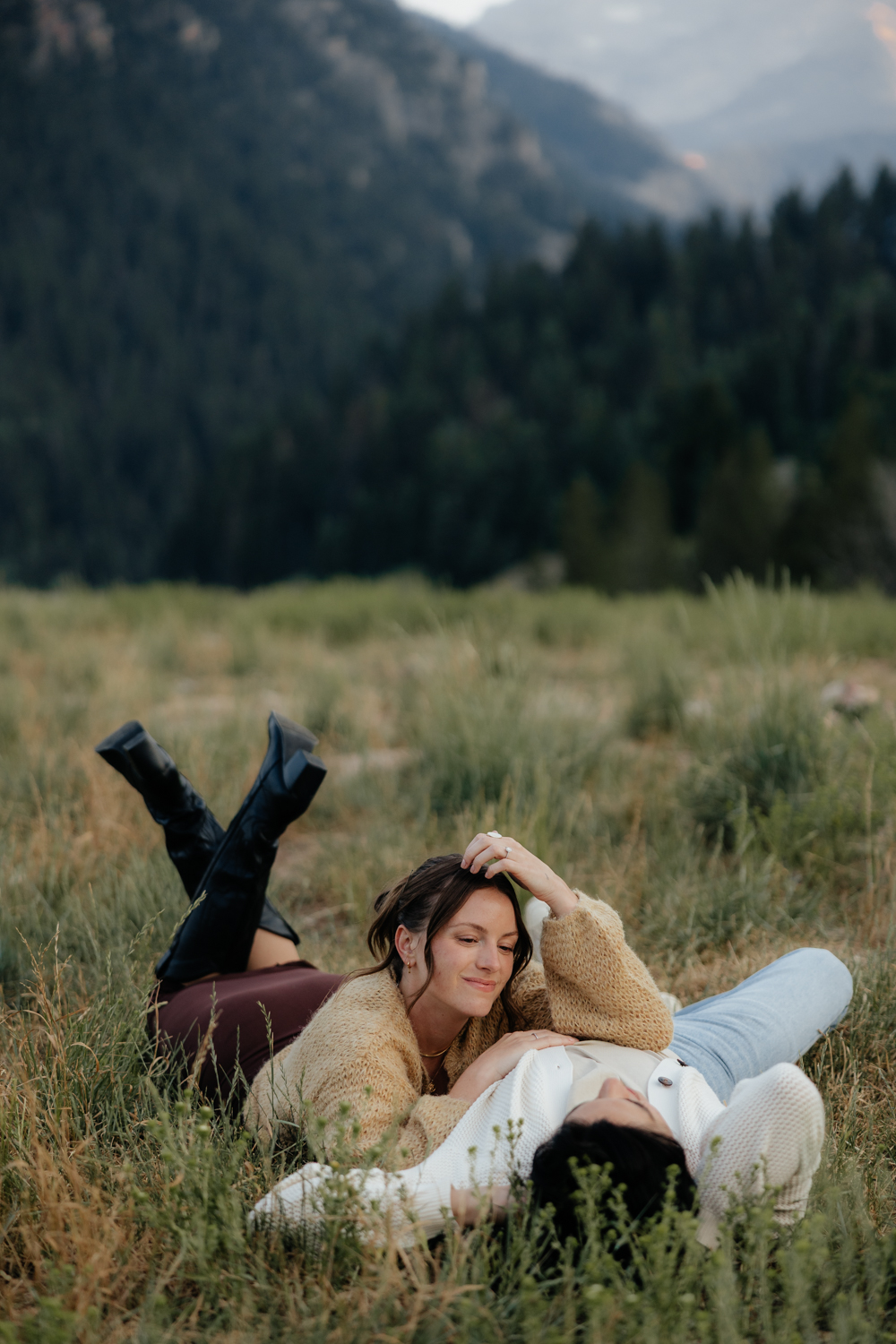 Couple plays in the grass at TIbble Fork Reservoir in Utah