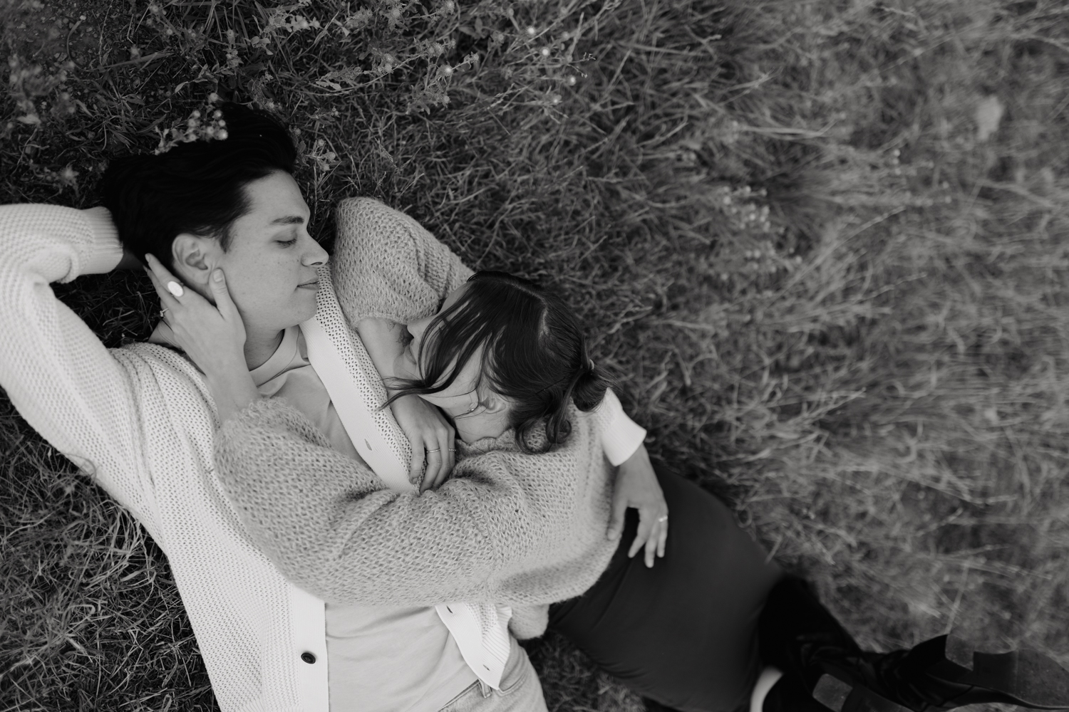 Couple plays in the grass at TIbble Fork Reservoir in Utah