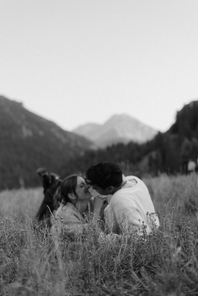 Couple plays in the grass at TIbble Fork Reservoir in Utah
