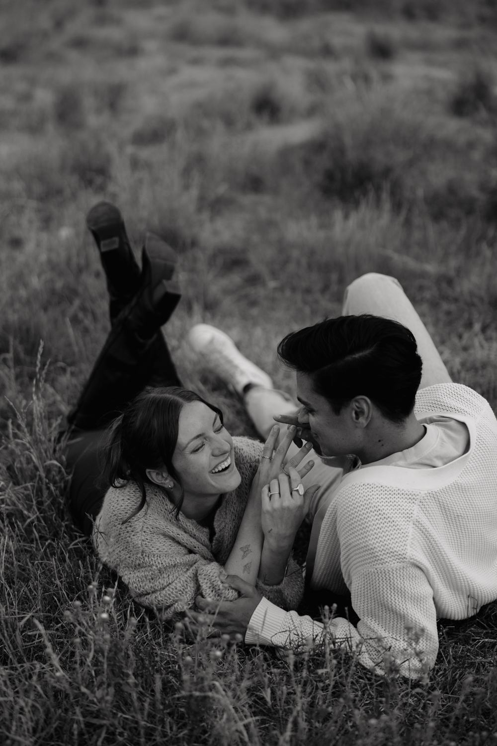 Couple plays in the grass at TIbble Fork Reservoir in Utah