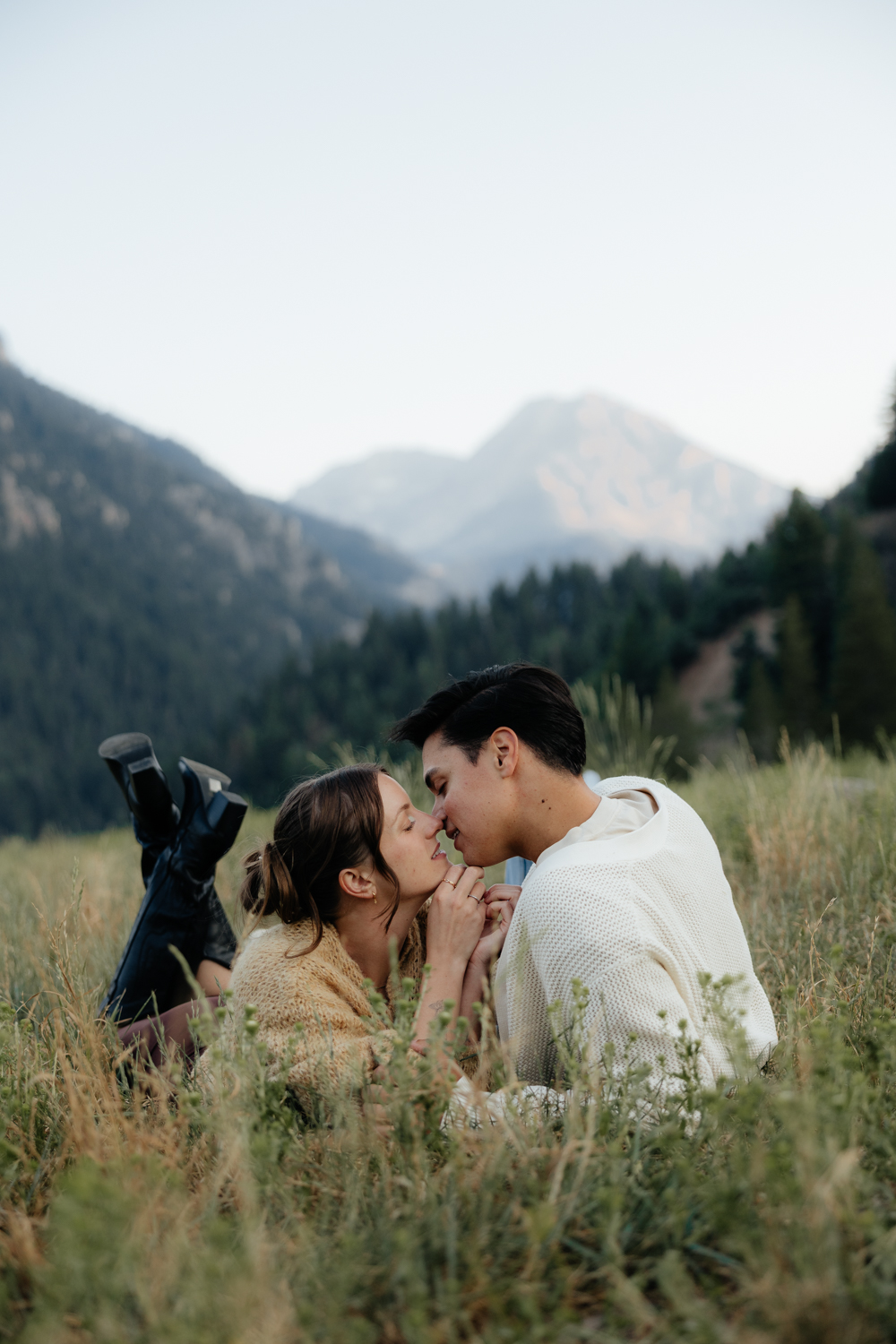 Couple plays in the grass at TIbble Fork Reservoir in Utah